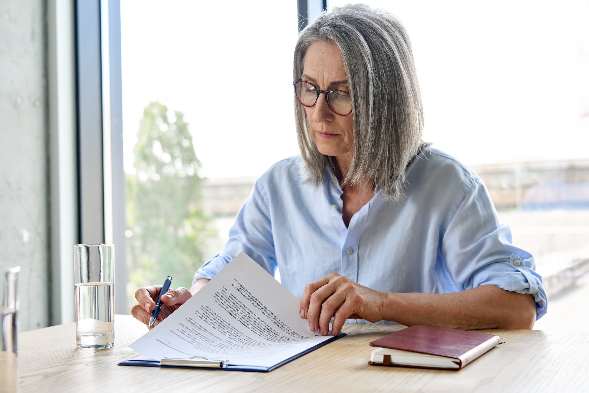 Professional reviewing documents during a defense consultation regarding employment practices. Professional reviewing documents during a defense consultation regarding employment practices.